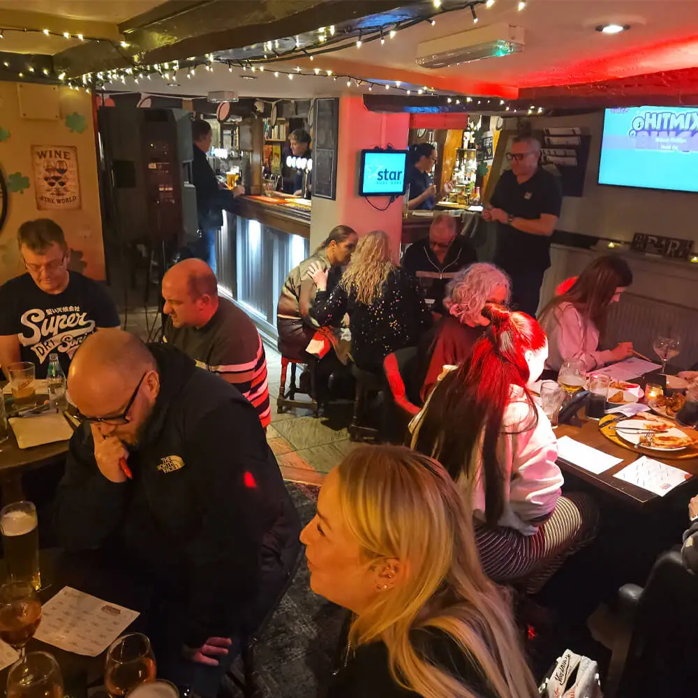 Adults playing HitMix Bingo at a pub entertainment night hosted by Music and Mayhem.
