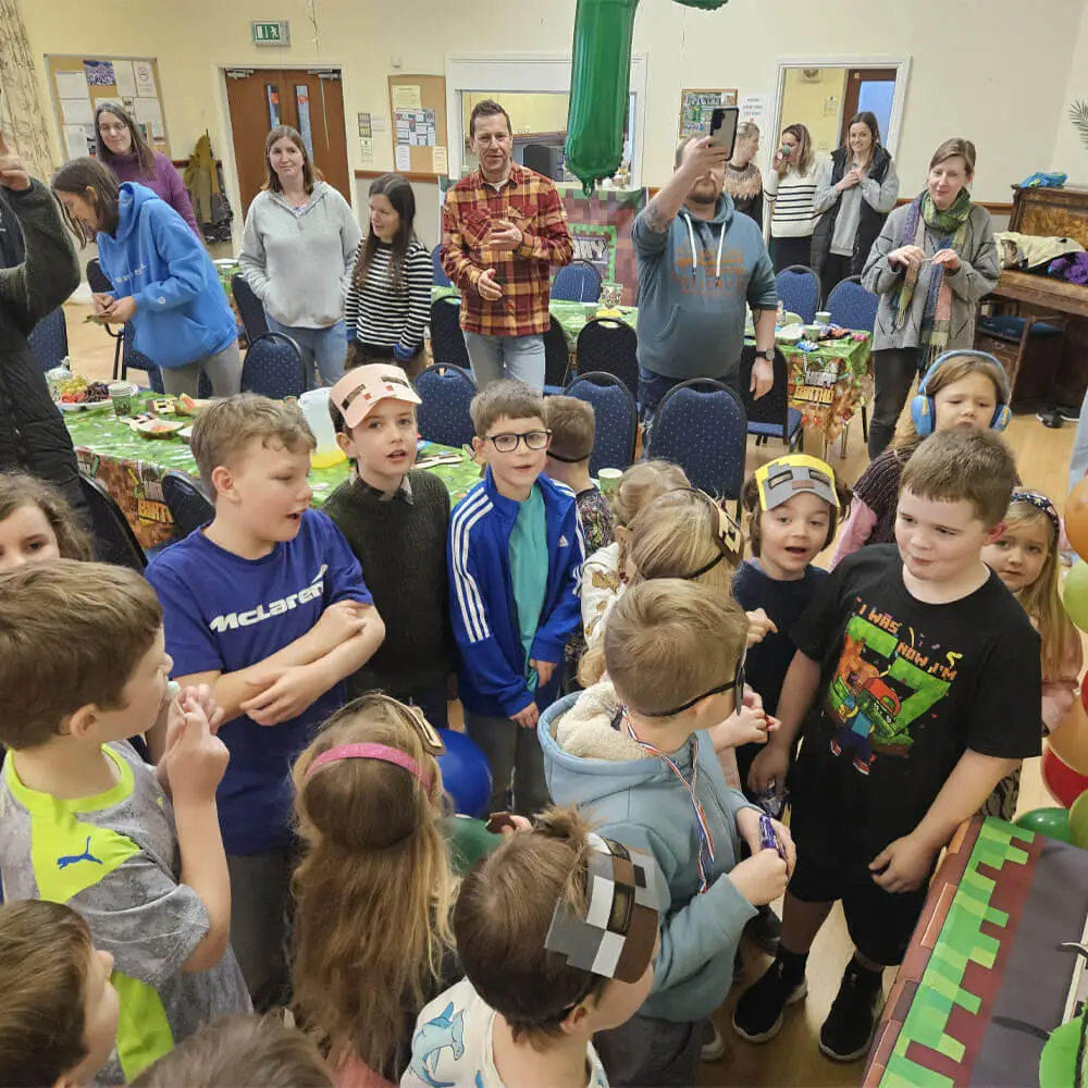 Children wearing Minecraft masks gathering for a 7th birthday party hosted by Music and Mayhem to start the 2026 season.