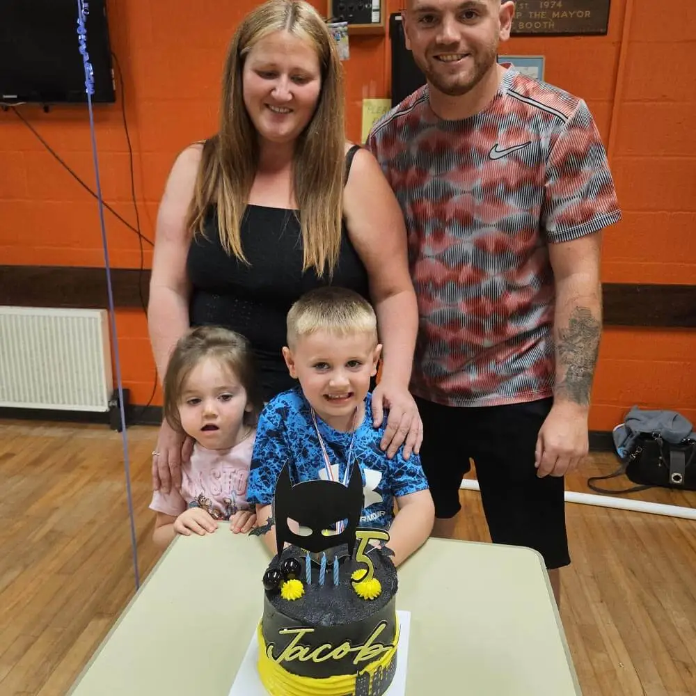 Family gathering around a custom Batman-themed birthday cake for a 5th birthday party celebration hosted by Music & Mayhem in Lancashire.
